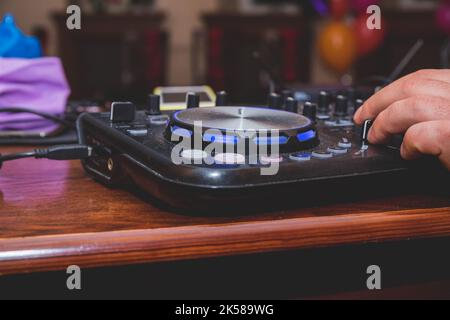 DJ Hands creating and regulating music on dj console mixer in concert outdoor.DJ mixer controller panel for playing music and partying. Stock Photo