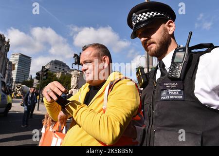 London, UK. 06th Oct, 2022. A protester is being arrested during the demonstration at Trafalgar Square. Climate activists group Just Stop Oil blocked the roads around Trafalgar Square on the 6th day of Occupy Westminster action, demanding to halt all future licensing and consents for the exploration, development and production of fossil fuels in the UK. Credit: SOPA Images Limited/Alamy Live News Stock Photo