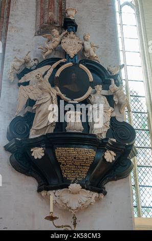 Germany, Lubeck - July 13, 2022: Marienkirche. Closeup of Gotthard-Kerkring Epitaph, white sculptures on black with time-darkened painting of the man Stock Photo