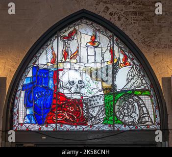 Germany, Lubeck - July 13, 2022: Marienkirche, Closeup of modern-style, colorful, stained window featuring skull and flames Stock Photo