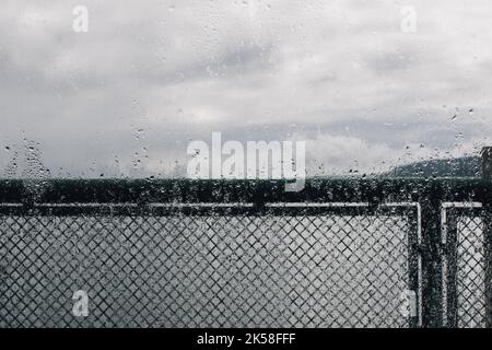 rain drops water on Pacific Northwest ferry boat window looking out at the puget sound Stock Photo