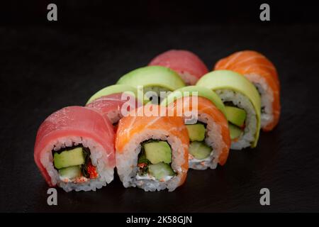 Different types of delicious and juicy sushi and rolls on a black background Stock Photo
