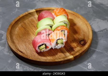 Different types of delicious and juicy sushi and rolls on a wooden board Stock Photo