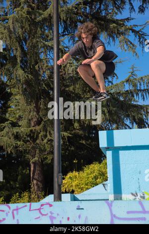 young male athlete doing parkour jumps and acrobatic exercises in the ...