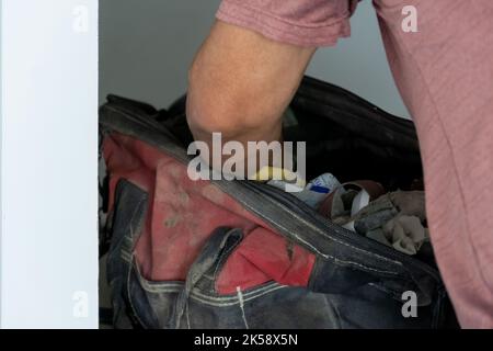 latino man looking for tools in his toolbox, hispanic, with screwdriver in hand Stock Photo