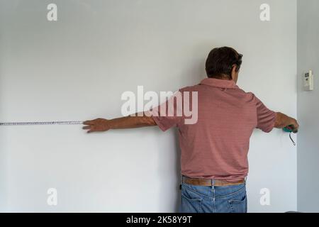 old man preparing for doing apartment repair by hisselfes. Before home makeover or renovation. Stock Photo