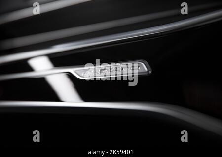 The Chrome Quattro Dashboard Badge On Piano Black Background With Red Mood Lighting On A 2021 Audi RS6 Stock Photo