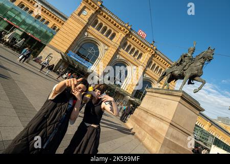 31.05.2022, Germany, Lower Saxony, Hannover - Young people making faxes, Hannover main station with Ernst-August monument (1861). 00A220531D454CAROEX. Stock Photo