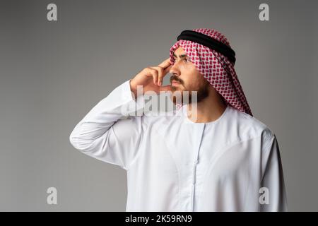 Young arab man wearing traditional clothes thinking about something Stock Photo