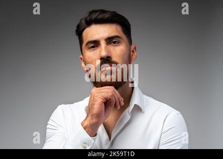 Studuo shot of thinking businessman standing over gray background Stock Photo