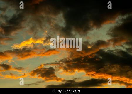 Dark black yellow red light rays flashed inside the cloud. Amazingly beautiful evening when the sun is setting in the western sky Stock Photo