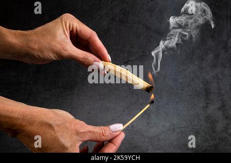 palo santo burning in front of dark background Stock Photo