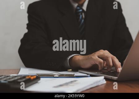 Business man using computer laptop and paperwork on desk. Stock Photo