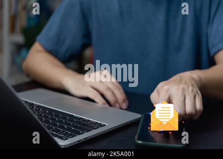 businessman holding hand touchscreen smartphone and checking email icon online or sending mail to partner and customer on web with virtual interface t Stock Photo