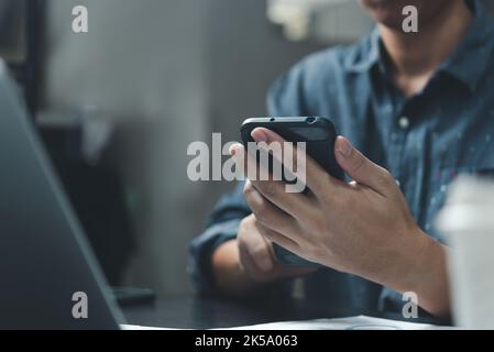 Businessman using smartphone marketing laptop computer business network manager. man using notebook internet online technology communication. Stock Photo