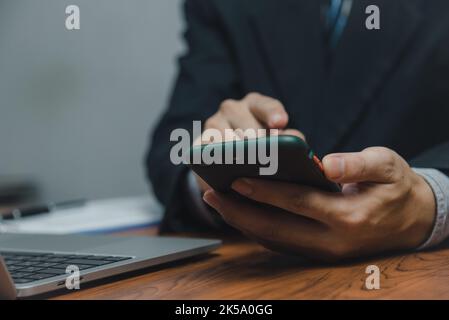 Businessman using smartphone marketing laptop computer business network manager. man using notebook internet online technology communication. Stock Photo
