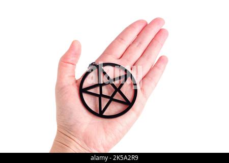 Large black pentagram shape placed on a hand palm isolated on white. Stock Photo