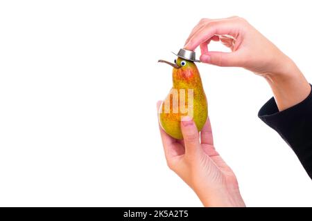 Woman puts a cowboy hat on cute kiwi-bird like pear character isolated on white background. Stock Photo