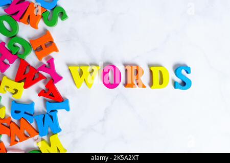 Multicolored wooden letters arranged into WORDS word on white. Creative learning concept. Stock Photo