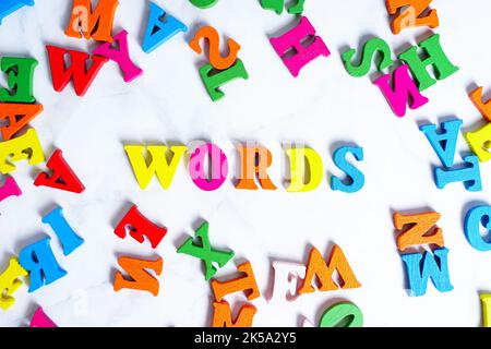 Lettering WORDS made from colorful wooden characters on gray. Bright concept of learning new words. Stock Photo