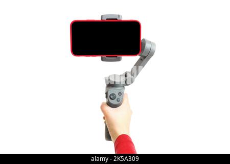 Shooting smartphone video using a handheld gimbal stabilizer isolated on white background Stock Photo