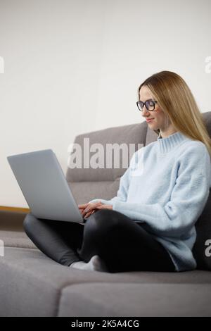 Person typing text on notebook computer. Programmer woman coding on laptop computer at home. Stock Photo