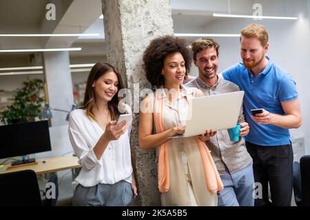 Group of software engineers working developing applications together in corporate office Stock Photo