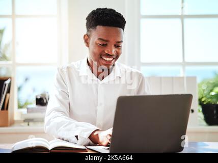 Laptop, typing and schedule with a black man graphic designer working online with his computer and notebook. Email, creative and internet with a young Stock Photo