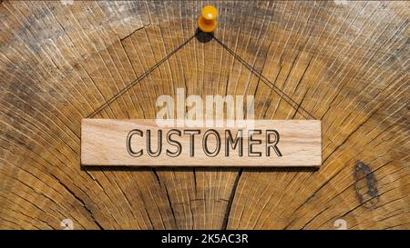 customer text . Written on wooden hanging frame. Background wood cut log. Stock Photo