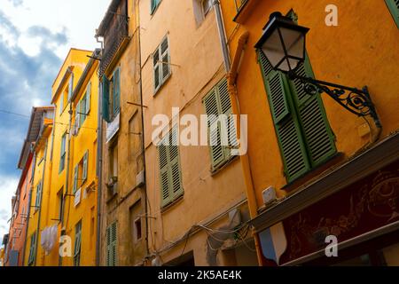 Colorful mediterranean houses and narrow winding streets, hilly backstreets in Provence small town of Menton on the French Riviera, in the Alpes-Marit Stock Photo