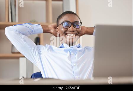 Black man, relax and laptop in office break, social media or web browsing after successful business deal. Leader, ceo or manager in Nigeria resting Stock Photo