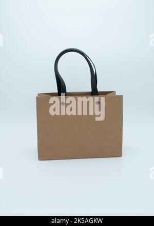 Brown paper bag with black handles on a white background Stock Photo