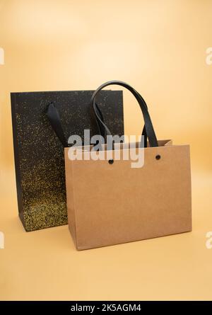 Two gift paper bags on a textured yellow and brown background Stock Photo