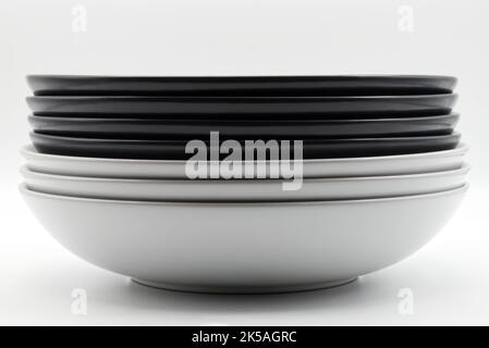 Stack of black and white dishes isolated on white background Stock Photo