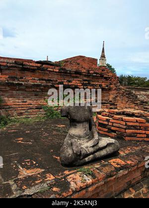 A vertical shot of an old headless Buddha statue at Ayutthaya, Thailand, in daylight Stock Photo