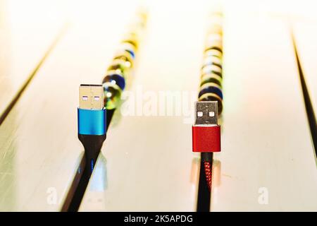 Connect and send. Blue and red usb cables on stripe surface Stock Photo