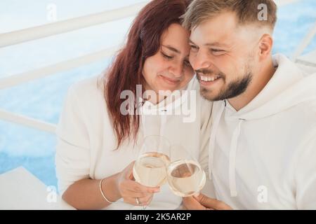 A man and a woman are sitting in a cafe and drinking white wine.  Stock Photo