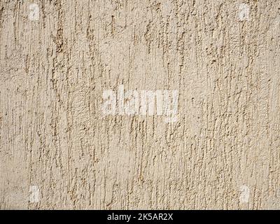Beige textured wall with plaster applied with putty knife in irregular dashes and strokes Stock Photo