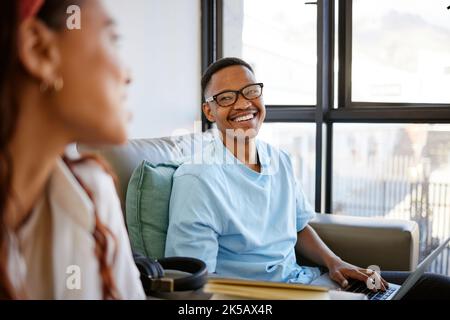 Happy students, teamwork or education man with smile on laptop in school, college or university classroom. Smiling, laughing or excited male on sofa Stock Photo