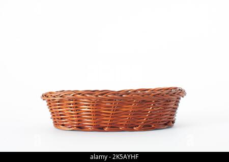 Empty, wooden and brown color weave wicker basket isolated on white background with selective focus. Stock Photo