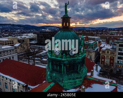 An aerial shot of a green temple in downtown Binghamton, during an orange sunset Stock Photo