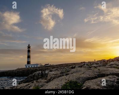 Sunset at Cap d'Artrutx lighthouse in Menorca. Favourite walk for holiday makers at Cala n Bosc as the lighthouse is a restaurant and bar. Stock Photo