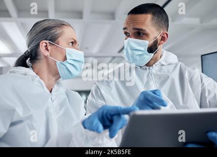 Scientist team, covid research and tablet with doctors discussing medical information, analysis and teamwork in lab. Medical man and woman using Stock Photo