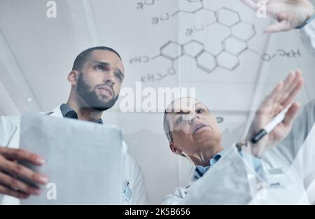 Scientist team, science and chemistry formula on glass board while solving or discuss experiment or solution in a medical laboratory. Innovation Stock Photo