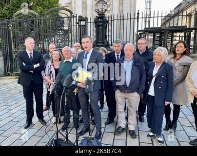 John McEvoy (centre-left) with solicitor Gavin Booth (centre-right), Sinn Fein MP for South Down Chris Hazzard (left) and survivors of loyalist gun attacks outside the High Court in Belfast. Mr McEvoy, is a survivor of a 1992 loyalist gun attack at the Thierafurth Inn in Kilcoo, Co Down, has brought a legal challenge against the chief constable of the Northern Ireland Police Service. Picture date: Friday October 7, 2022. Stock Photo