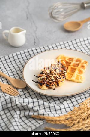 Croffles with almonds chocolate sauce topping and caramel on plate Stock Photo