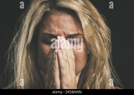 Stress, anxiety and depression with a mental health woman suffering from a headache or migraine in a studio on a dark background. Cancer and sad young Stock Photo