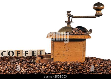Old manual coffee grinder with roasted coffee beans and the text Coffee made of wooden blocks, isolated on white background, photography. Stock Photo