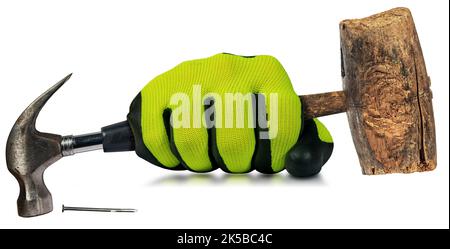 Hand with work glove holding an old steel claw hammer with black rubber handle and an old wooden mallet or hammer. Isolated on white background. Stock Photo
