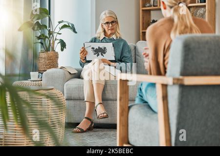 Therapist, psychologist and woman patient for ink test, therapy session and conversation about depression, mental health and problems. Female Stock Photo